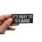 It's Okay To Stare Funny Iron on Patch shown on hand for size comparison