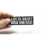 Life Is Short Break Some Rules Iron on Morale Patch shown on hand for size comparison