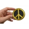 Peace Sign Patch  Yellow On Black Peace Sign Iron on Patch Yellow On Black shown on hand for size comparison