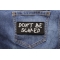 Don't Be Scared Patch shown on jeans
