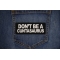 Don't Be a Cuntasaurus Patch shown on jeans