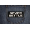 Never Settle Patch shown on jeans