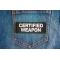 Certified Weapon Patch shown on jeans
