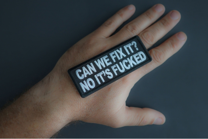 Can We Fix It? No Its Fucked Patch shown on hand for size comparison