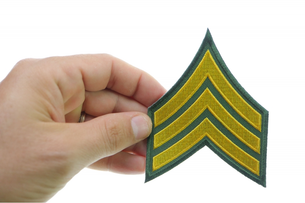 Green and Yellow Sergeant Chevron Iron on Patch shown on hand for size comparison