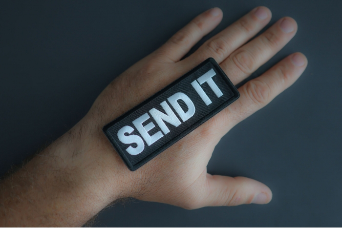 Send It Patch shown on hand for size comparison