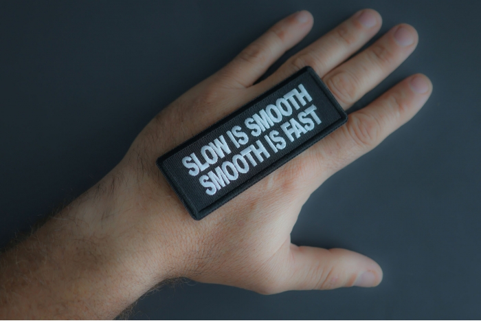 Slow Is Smooth Smooth Is Fast Patch shown on hand for size comparison