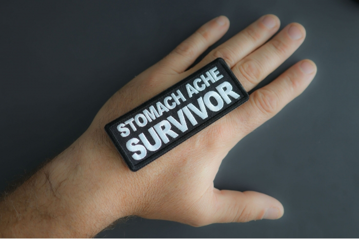 Stomach Ache Survivor Patch shown on hand for size comparison