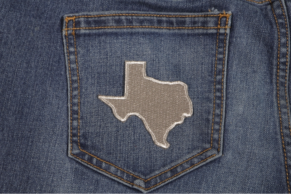 Silver Embroidered Texas Map Iron on Patch shown on jeans