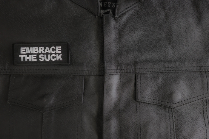 Embrace The Suck Patch shown on leather vest