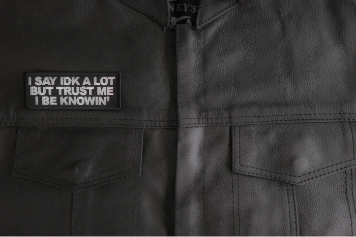I Say Idk A Lot But Trust Me I Be Knowin' Patch shown on leather vest