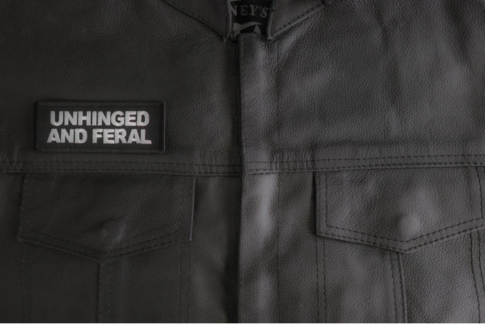 Unhinged And Feral Patch shown on leather vest