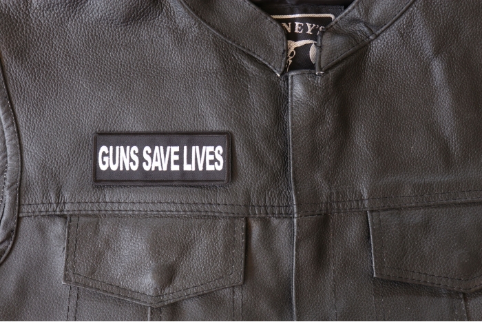 Guns Save Lives Patch - 4x1.5 inch - Embroidered Iron on Patch shown on leather vest
