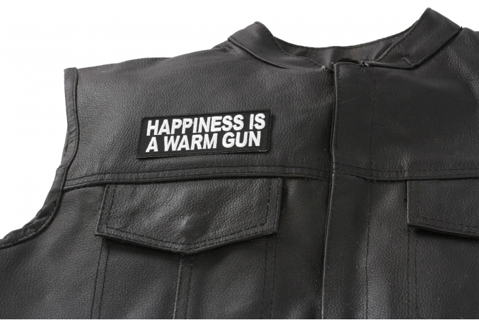 Happiness Is A Warm Gun Patch - 4x1.5 inch. Embroidered Iron on Patch shown on leather vest