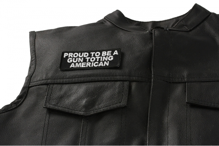 Proud to Be A Gun Toting American Patch - 4x1.5 inch. Embroidered Iron on Patch shown on leather vest