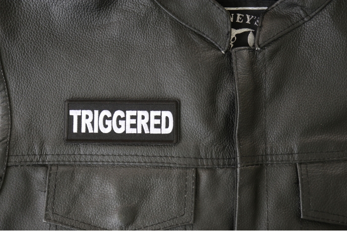 Triggered Patch - 4x1.5 inch - Embroidered Iron on Patch shown on leather vest