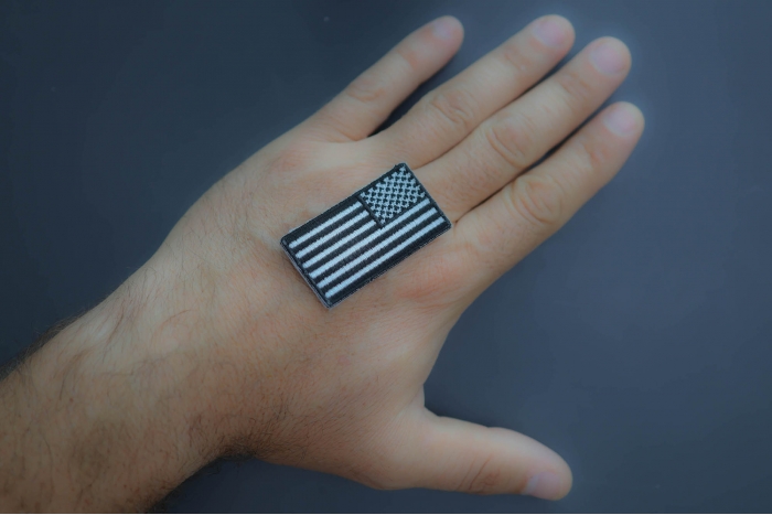 American Flag Patch reversed 2 inch black and white shown on hand for size comparison