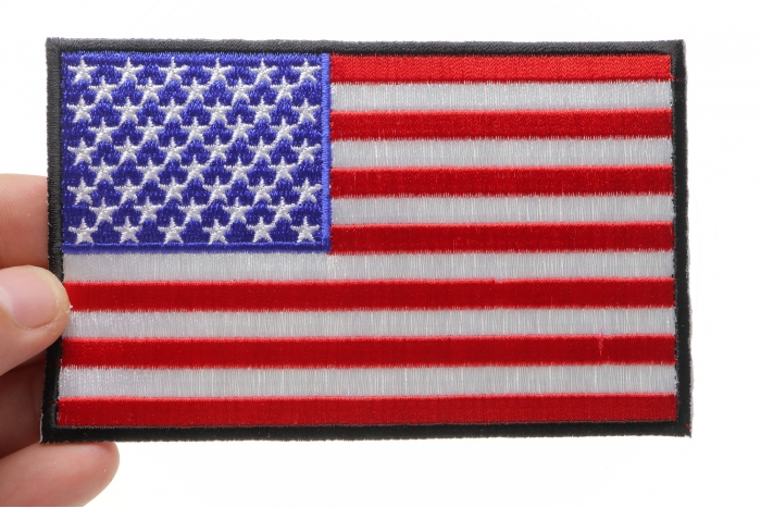 American Flag Patch with Black Borders shown on hand for size comparison