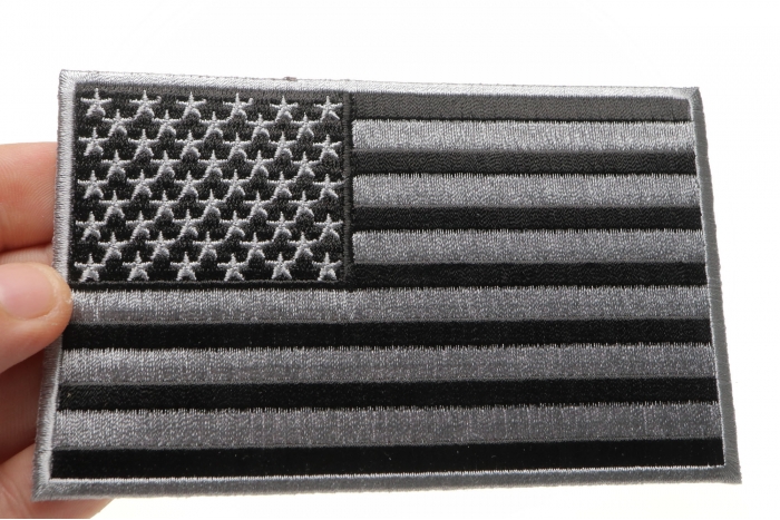 Black and Gray American Flag Patch shown on hand for size comparison