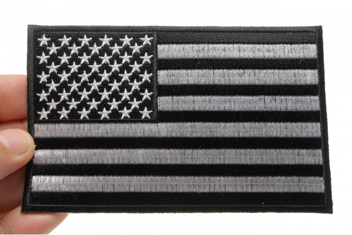Black and White American Flag Patch with Black Borders shown on hand for size comparison