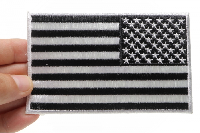 Black and White American REVERSED Flag Patch with White Borders shown on hand for size comparison