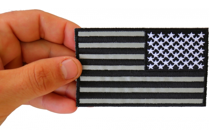 Reversed American Flag Black and Reflective 4 Inch Patch shown on hand for size comparison
