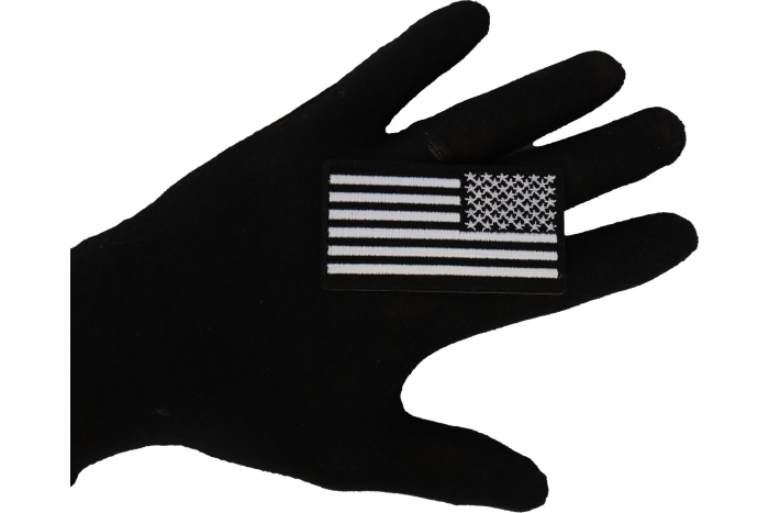 Reversed black and white 3 inch American Flag Patch shown on hand for size comparison