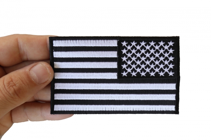 Reversed US Flag Black White Patch 4 Inch shown on hand for size comparison