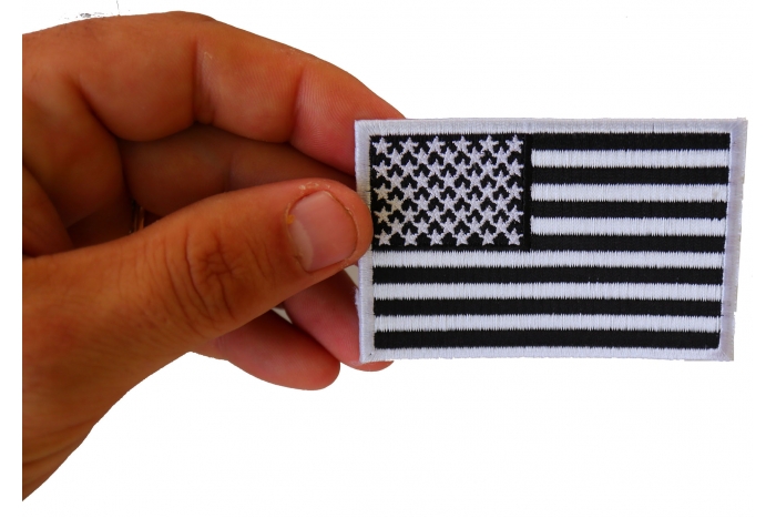 Subdued Black White US Flag Patch shown on hand for size comparison