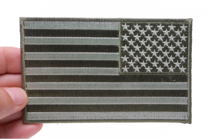 Subdued Green American REVERSED Flag Patch shown on hand for size comparison