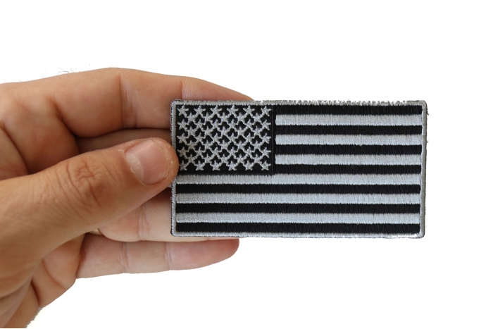 US Flag Patch Black and Gray 3.5 Inch shown on hand for size comparison