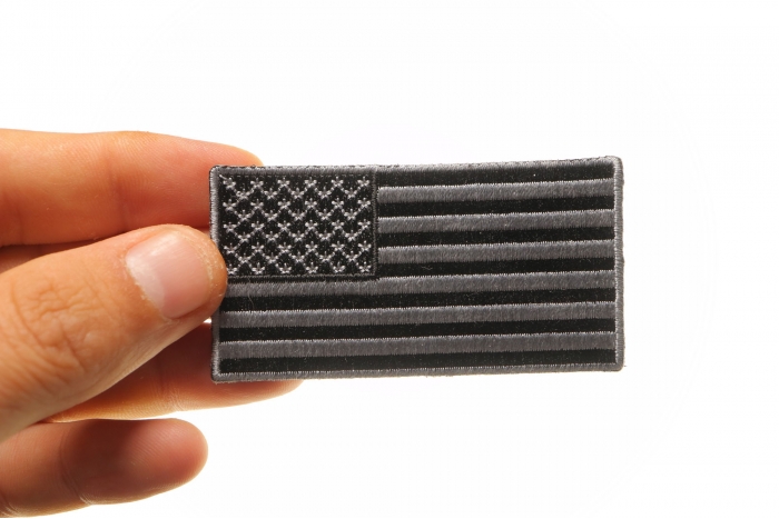 US Flag Patch Black and Gray 3 Inch shown on hand for size comparison