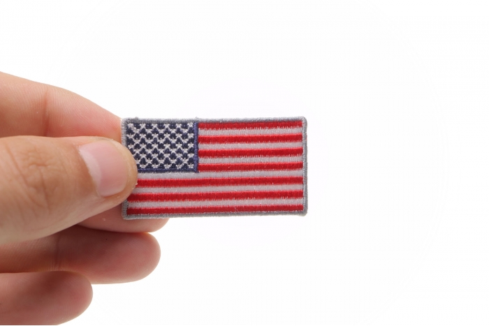 US Flag Patch Silver Border 2 Inch shown on hand for size comparison