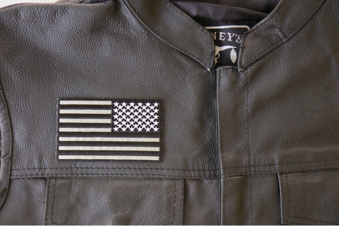 Reversed American Flag Black and Reflective 4 Inch Patch - 4x2.5 inch. Embroidered Iron on Patch shown on leather vest