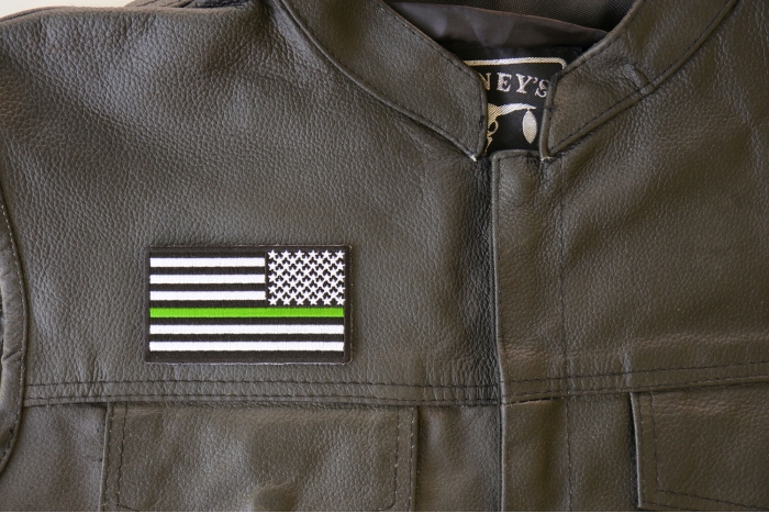 Thin Green Line American Flag Reversed Patch - 3.5x2 inch. Embroidered Iron on Patch shown on leather vest