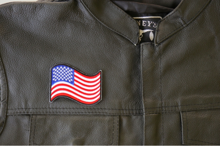 Waving US Flag Patch - 3x2.5 inch. Embroidered Iron on Patch shown on leather vest