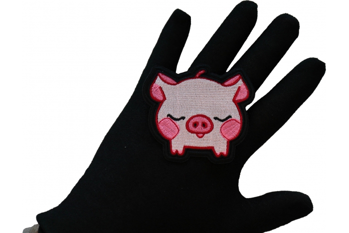 Kiss Me Piggy Iron on Patch shown on hand for size comparison