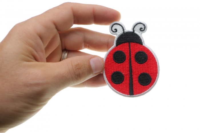 Lady Bug Iron On Patch shown on hand for size comparison