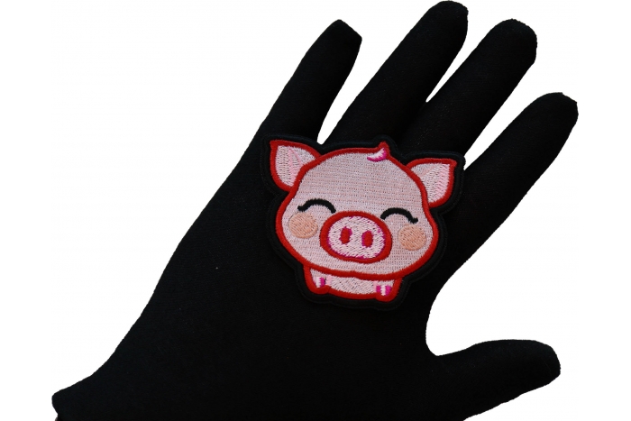 Piglet Iron on Patch shown on hand for size comparison