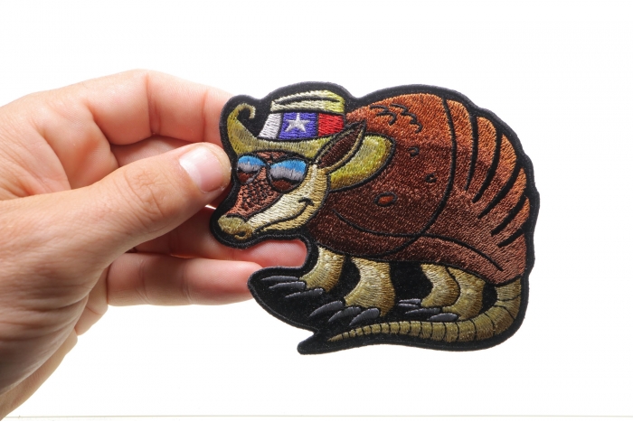 Armadillo Sew on Patch for Vests shown on hand for size comparison