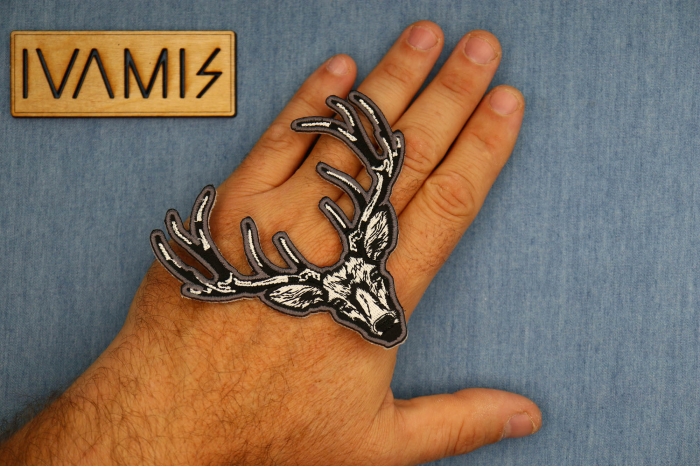 White Deer Head Patch shown on hand for size comparison