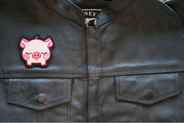 Kiss Me Piggy Iron on Patch shown on leather vest