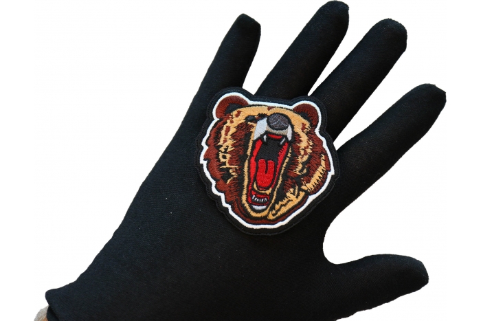 Yawning Bear Iron on Patch shown on hand for size comparison