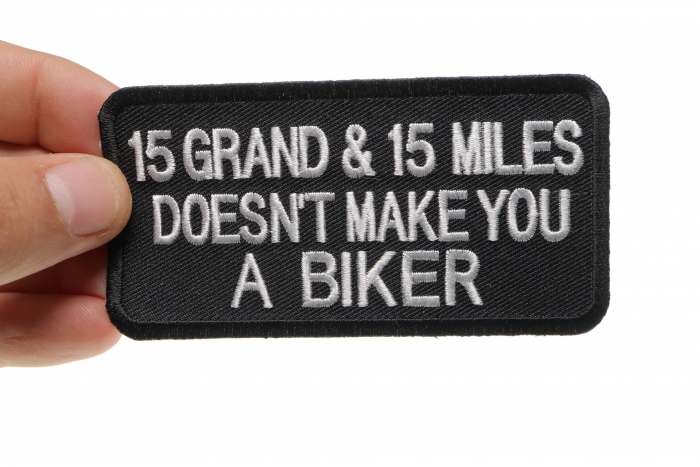 15 Grand 15 Miles Doesn't Make You A Biker Patch, Biker Saying Patches shown on hand for size comparison