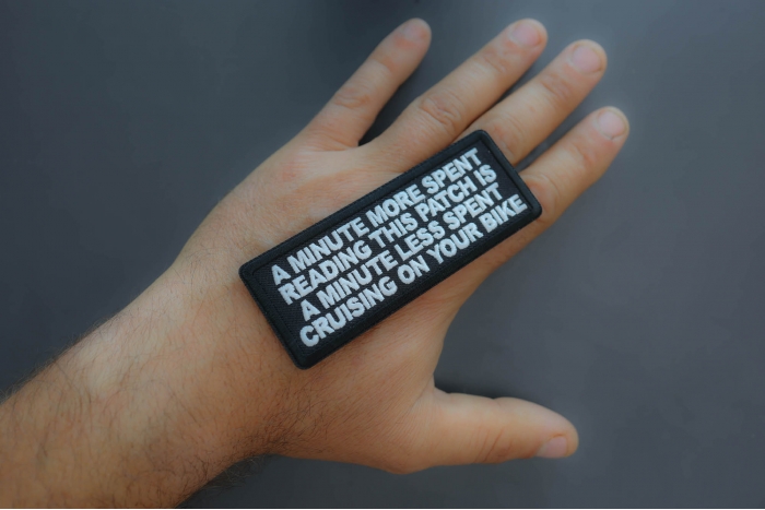 A minute more spent reading this patch is a minute less spent cruising on your bike patch shown on hand for size comparison
