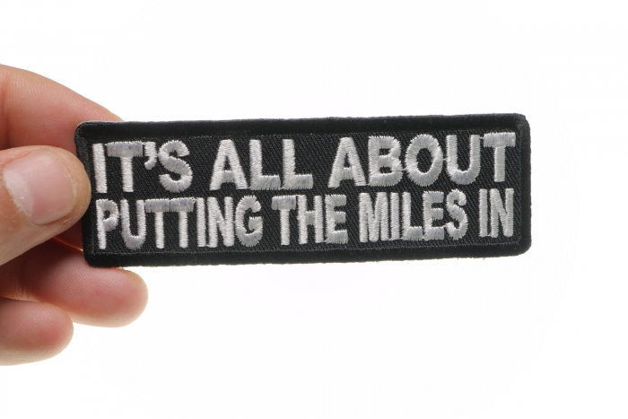 It's All About Putting The Miles In Patch, Biker Saying Patches shown on hand for size comparison