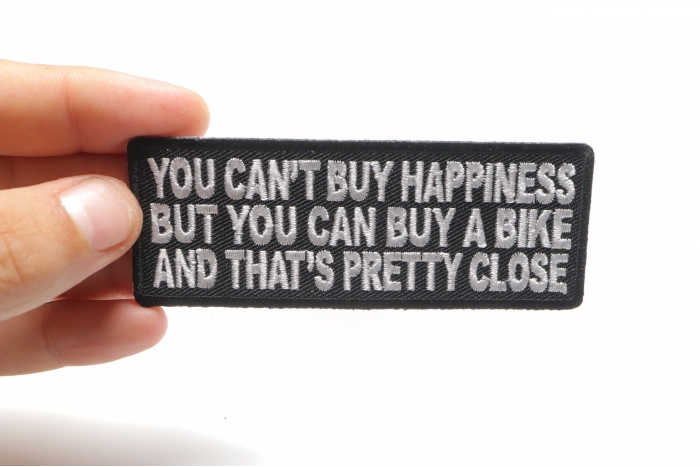 You Can't Buy Happiness But You Can Buy A Bike and That's Close Patch, Biker Saying Patches shown on hand for size comparison