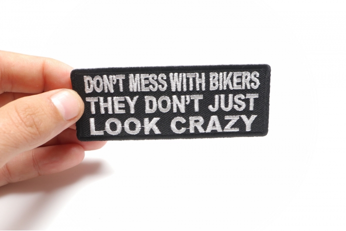Don't Mess With Bikers They Don't Just Look Crazy Patch, Biker Saying Patches shown on hand for size comparison