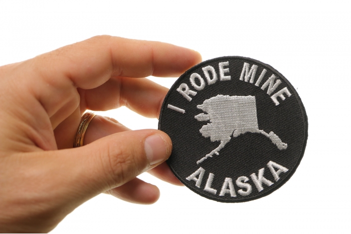 I Rode Mine To Alaska Biker Iron on Patch shown on hand for size comparison