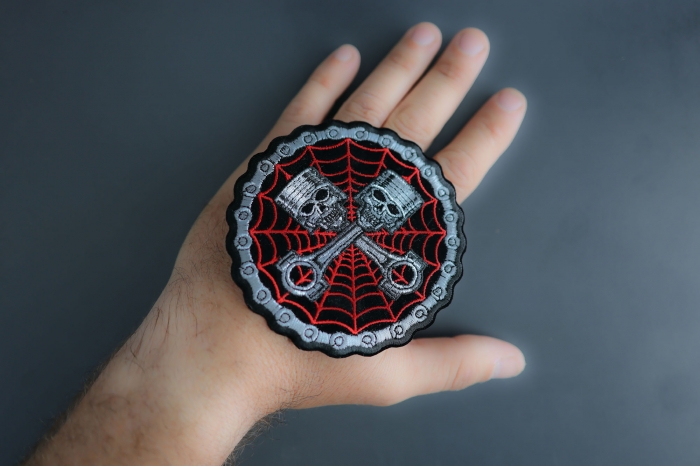 Piston Web Skulls Patch shown on hand for size comparison